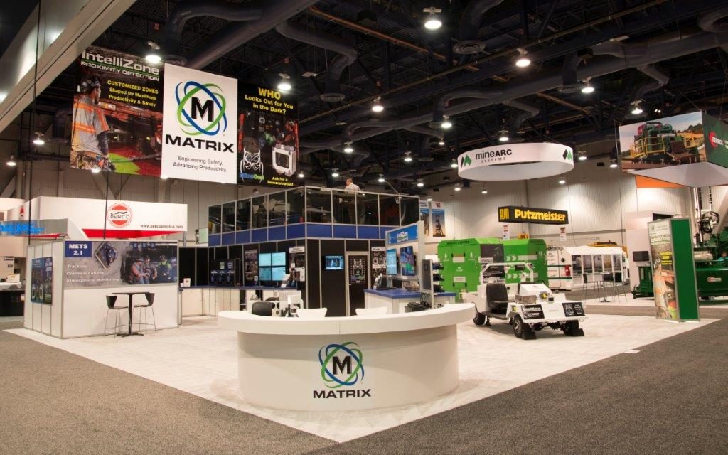 Multi-level trade show booth with staircase and meeting rooms